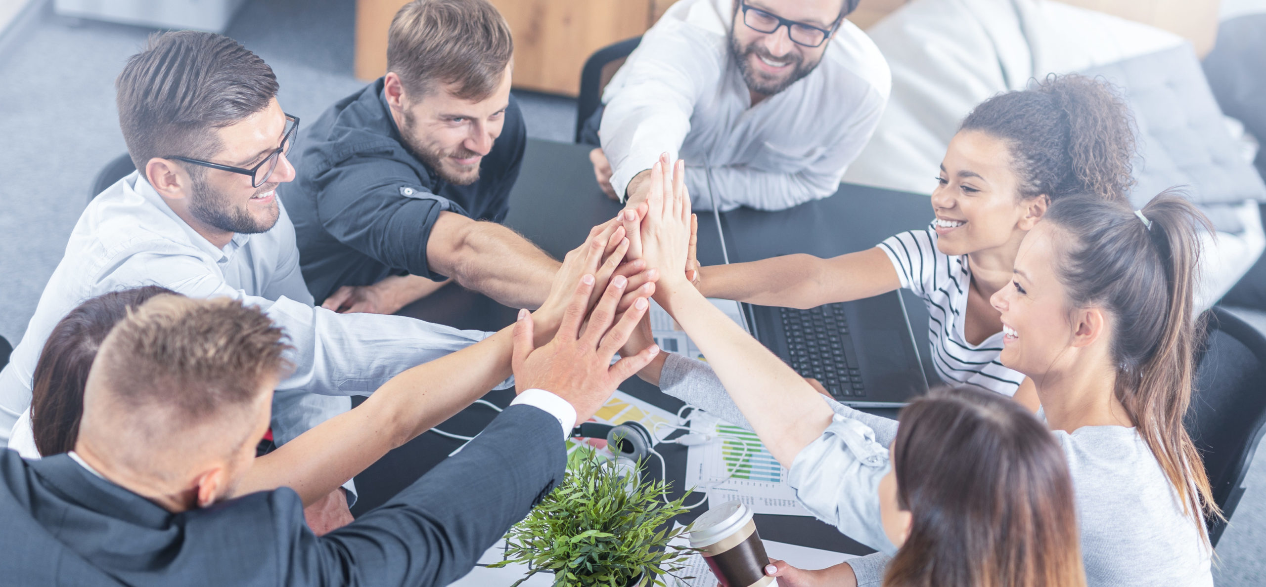 Happy business people team giving high five in office.
